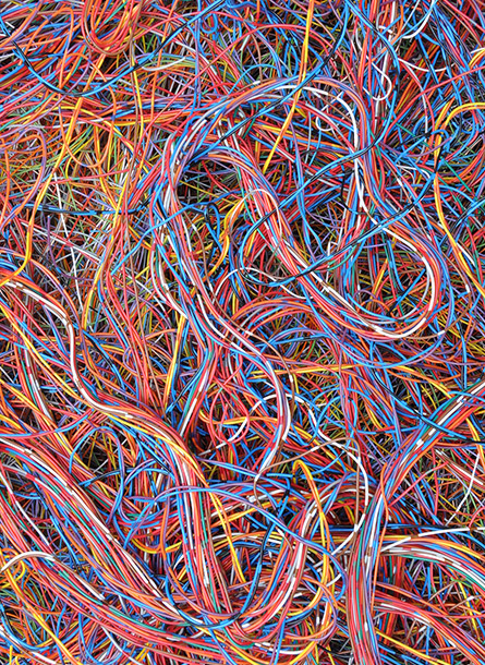 A dense tangle of colorful wires, including red, blue, yellow, and orange strands, creating a chaotic and intricate pattern.
