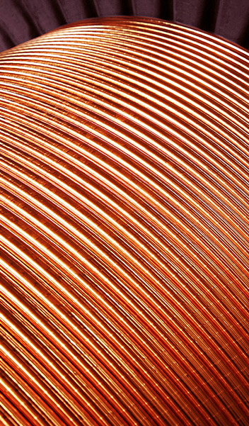 Close-up of curved, parallel copper tubes arranged in an overlapping pattern